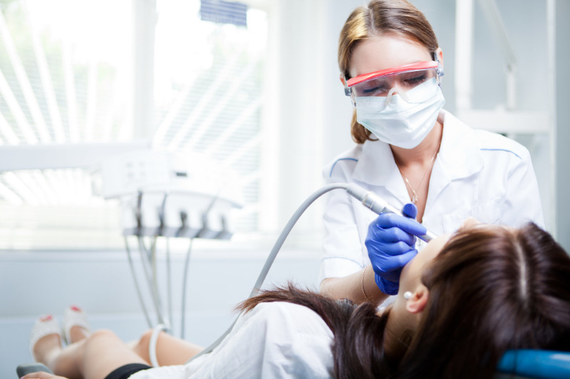 A dental hygienist cleaning patients teeth