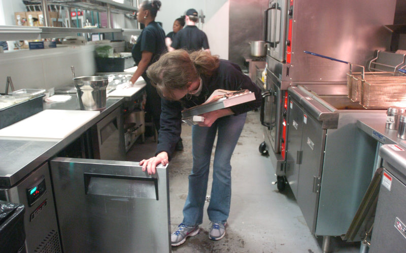 A female environmental health officer inspecting a restaurant kitchen