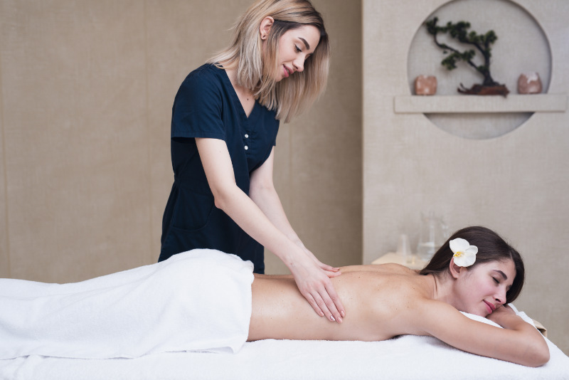 A massage therapist massaging the back of a client