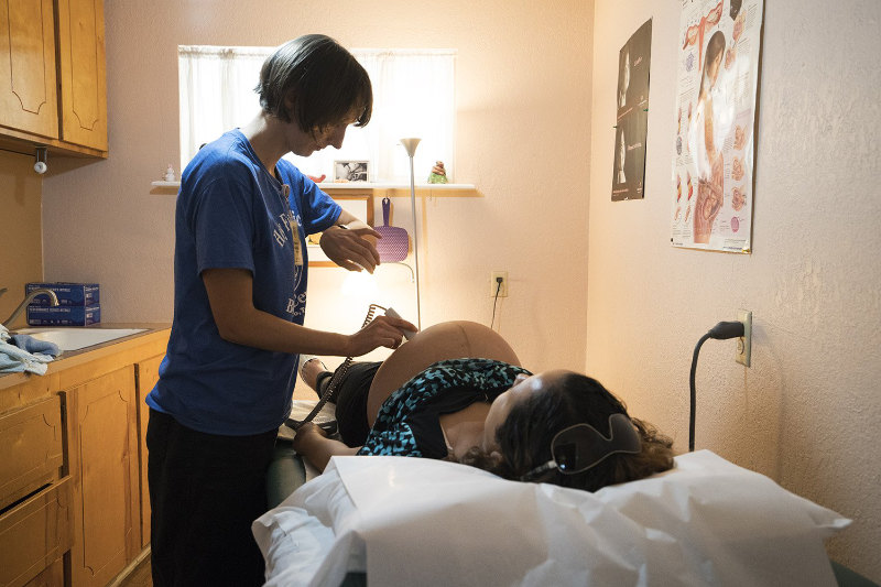 A midwife examining a pregnant woman