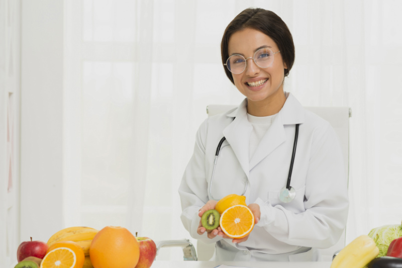 A young female nutritionist holding fruits in her hands