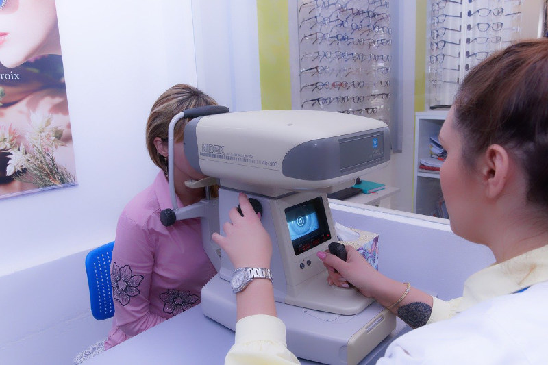 An optometrist examining patient's eyesight with an ophthalmoscope