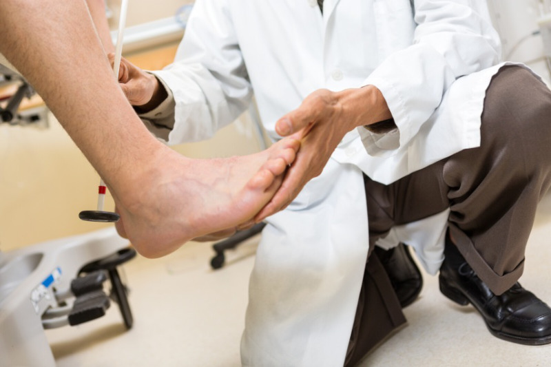 A pedorthist examining patient's foot