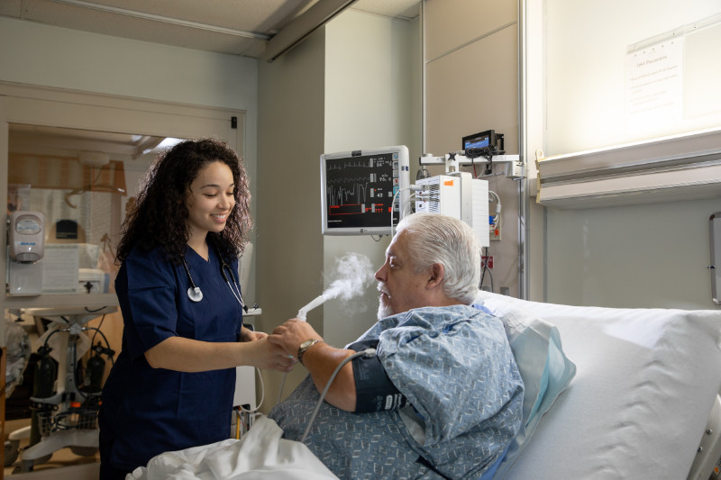 A female respiratory therapist administering a treatment to a patient