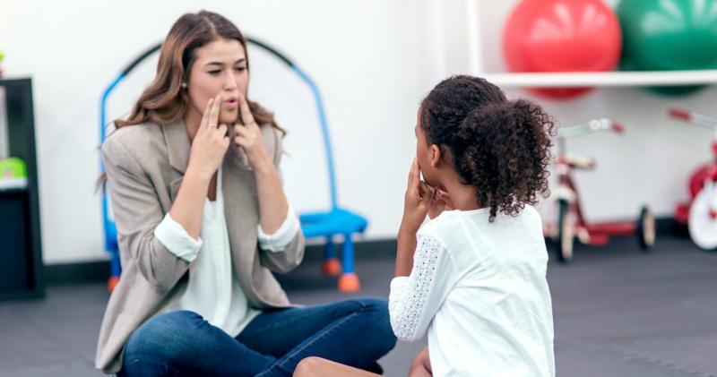 Speech and Language Pathologist helping a girl with speech disorder